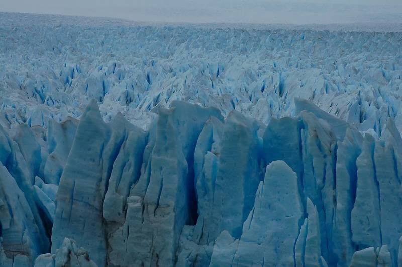 The ice of the glaciar shimmers in an incredible blue colour